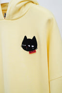 Black cat embroidery detail on yellow hoodie chest