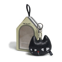 Black cat-shaped keychain with a red heart in front of a branded box on a white background