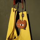 Yellow bag with a cat-shaped keychain on a dark background