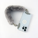 Phone with a fur-lined keychain strap case on a white background