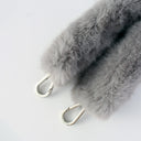 Gray fluffy keychain with metal carabiner on a light gray background