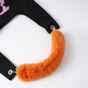 Orange fur strap tail attached to a black tote bag 