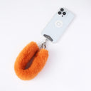 Orange fur keychain attached to a phone on a white background
