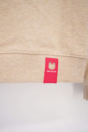 Red Toby Black logo tag on beige sweatshirt hem