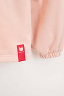 Close-up of red Toby Black cat logo tag detail