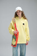 Model in yellow Toby Black hoodie with cat tote bag