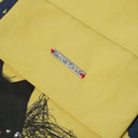 Metal TOBY BLACK plate with red thread detail on interior of yellow bag