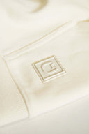 Close-up of cream embossed Toby Black cat logo tag