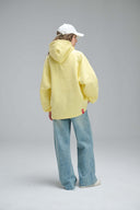 Model wearing yellow Toby Black hoodie back view