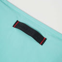 Toby Black woven label with red stitching on mint green nylon fabric