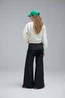 Model wearing cream Meow 2 Me sweatshirt with green cap back view